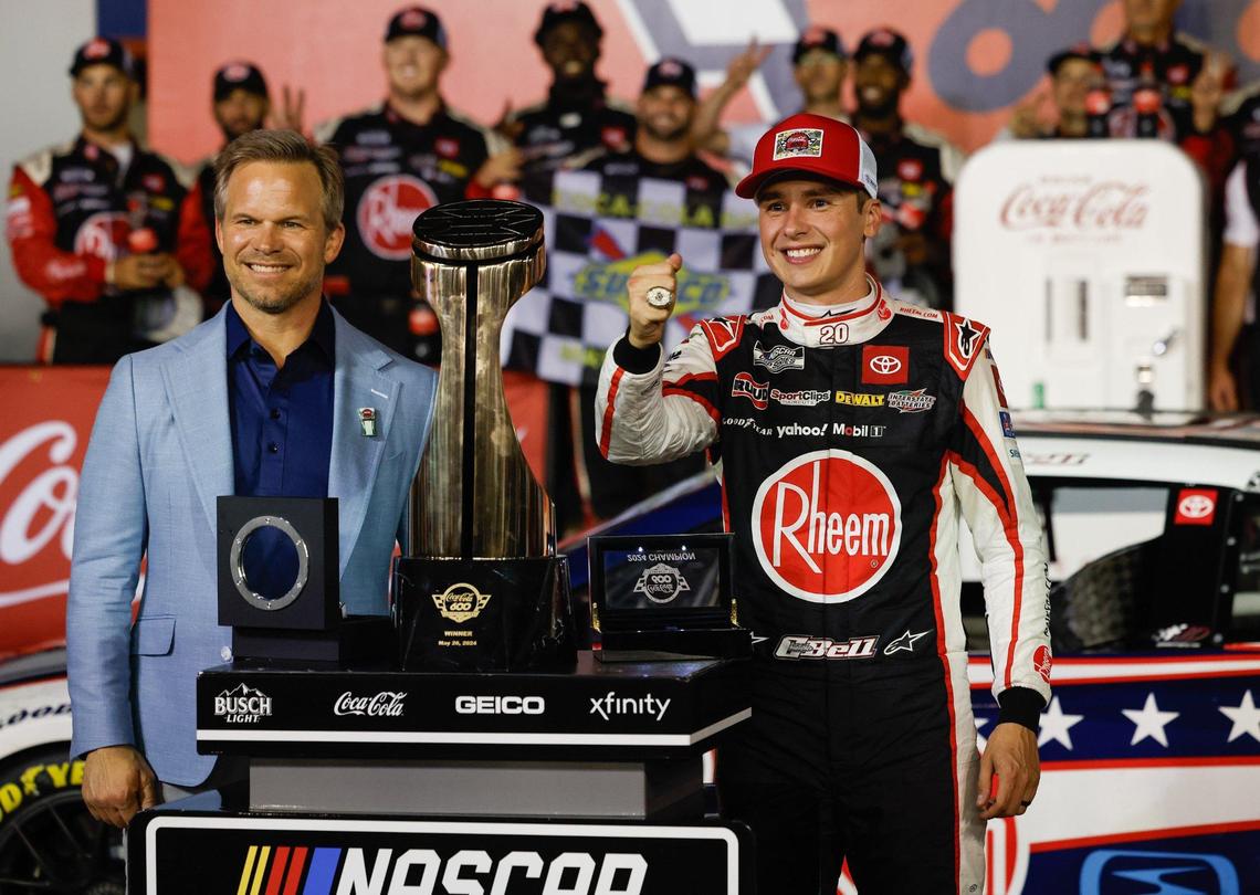 Speedway Motorsports president and CEO Marcus Smith, left, poses with Christopher Bell after presenting the driver with the Coca-Cola 600 championship ring.
