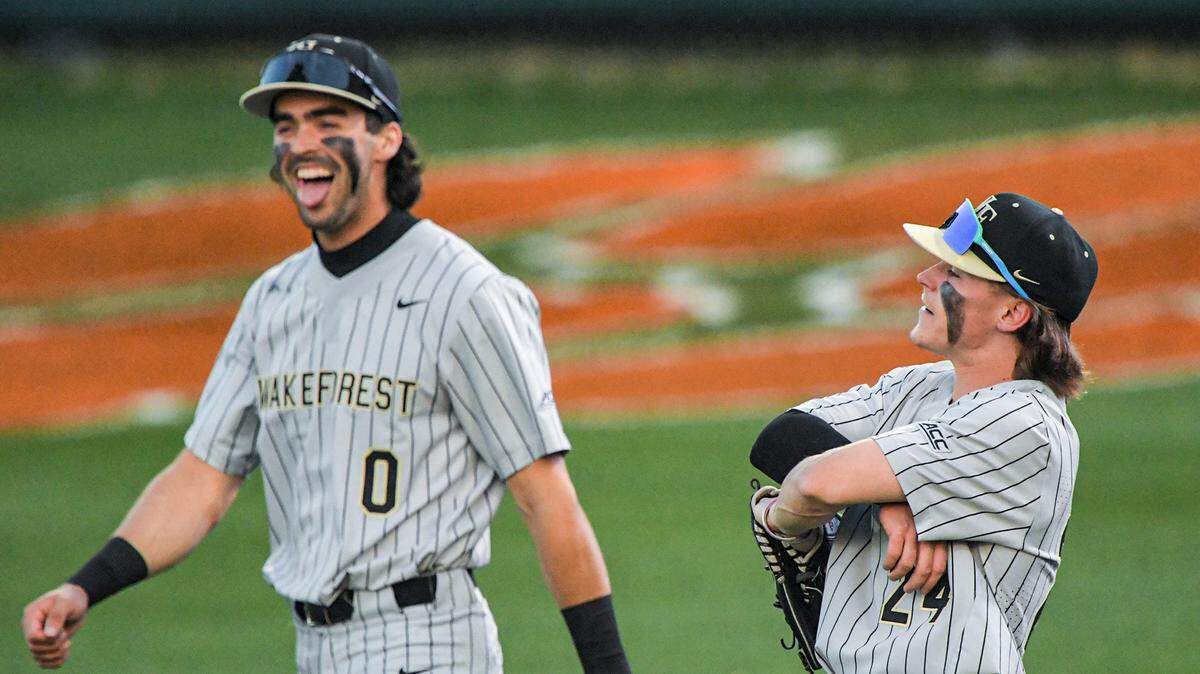 Wake Forest sophomore Tommy Hawke (24) reacts after pulling a home run ball back inside the field for an out after Clemson senior Riley Bertram (6) hit it to him, with Wake Forest junior Lucas Costello (0) reacts near him, during the bottom of the third inning at Doug Kingsmore Stadium in Clemson Thursday, March 30, 2023. Clemson Baseball Vs Wake Forest March 30 2023