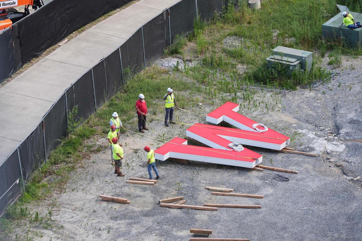 Workers prepare letters to be hoisted by a helicopter that will be placed on the top of the Wells Fargo building in uptown Charlotte on June 15, 2025.