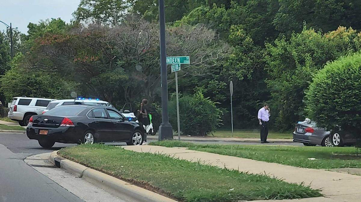 A Charlotte-Mecklenburg Police investigator looks over the scene of a shooting at the corner of Beatties Ford Road and Dundeen Street on Monday, June 27, 2022.