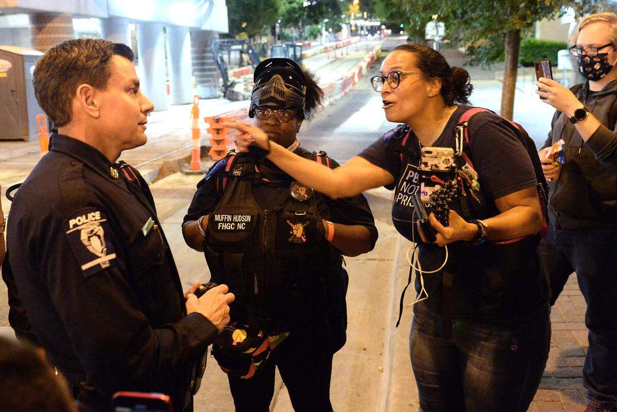 Kristie Puckett Williams, state campaign manager with ACLU NC, right, speaks with CMPD officer Brad Koch, left, in uptown Charlotte, NC on Thursday, June 4, 2020. Demonstrators marched for the seventh straight night in protest to the killing of George Floyd who died on Monday, May 25, 2020 in Minneapolis, MN when a police officer held his knee across Floyd’s neck for almost nine minutes.