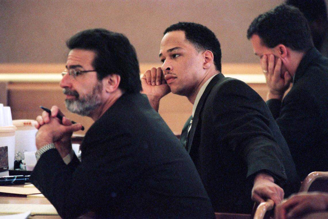 Former Carolina Panthers receiver Rae Carruth, center, and his attorney David Rudolf, left, listen to testimony from co-defendant Michael Eugene Kennedy during Carruth’s murder trial in Charlotte, N.C., Wednesday, Nov. 22, 2000. Kennedy testified that Carruth arranged shooting of Cherica Adams. (AP Photo/Jeff Siner, Pool)