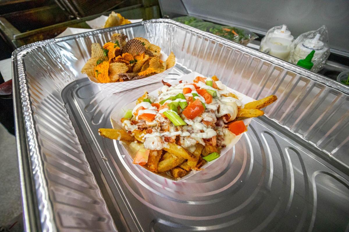 The smokey Bacon Fries at What The Fries are loaded and topped with ranch, green onions and tomatoes.