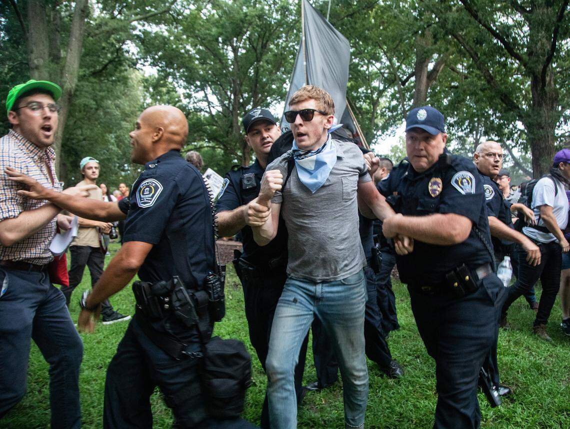 Police lead a protester away near the Silent Sam statue on the campus of UNC-Chapel Hill on Monday.
