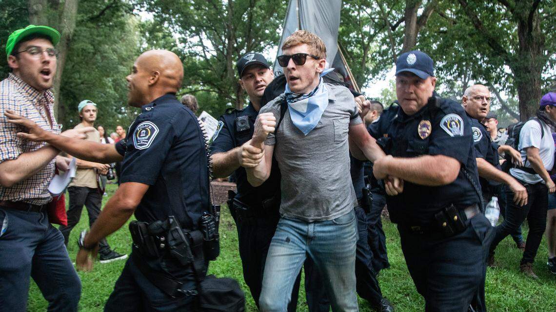 Police lead a protester away near the Silent Sam statue on the campus of UNC-Chapel Hill on Monday.