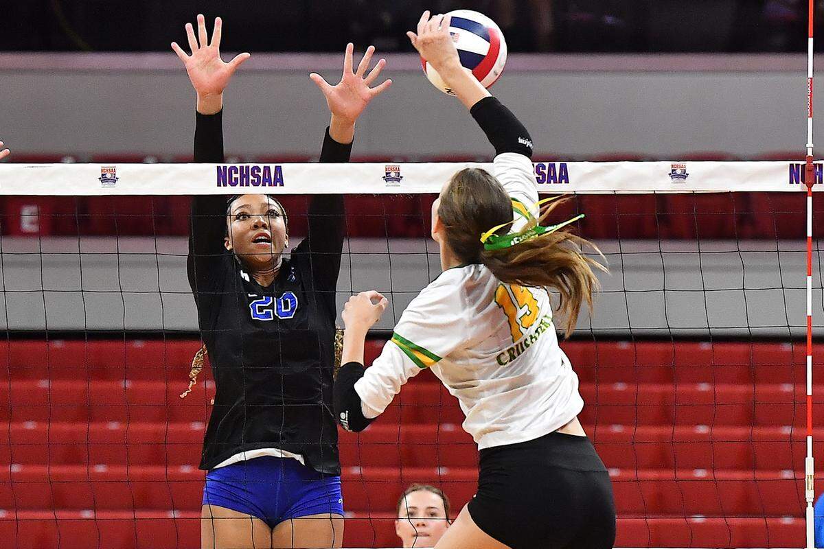 Cardinal Gibbons’ Katherine Barbour (19) spikes the ball against Marvin Ridge’s Victoria Simons (20) in the NCHSAA 4 A Volleyball Championship game. The Marvin Ridge Mavericks took on the Cardinal Gibbons Crusaders in the NCHSAA 4A Volleyball Championship match in Raleigh, N.C. on November 2, 2024.