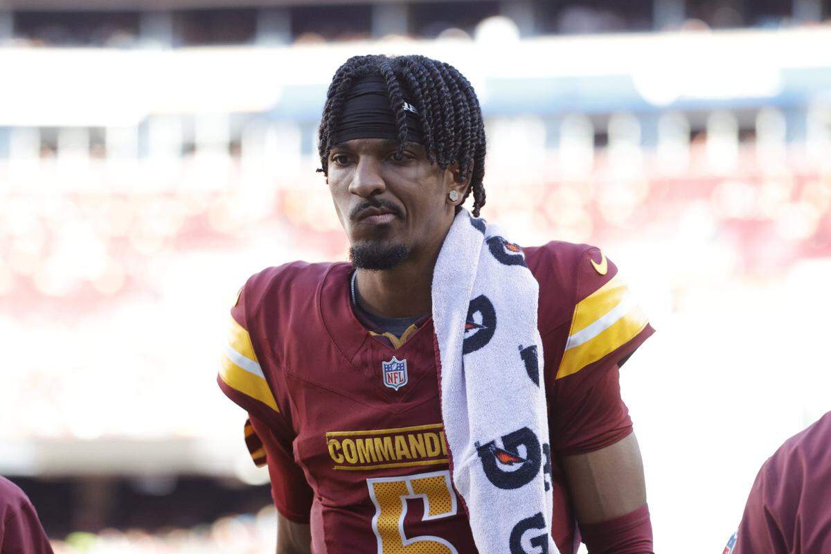 Oct 20, 2024; Landover, Maryland, USA; Washington Commanders quarterback Jayden Daniels (5) walks off the field during the first quarter after an injury against the Carolina Panthers at Northwest Stadium. Mandatory Credit: Amber Searls-Imagn Images