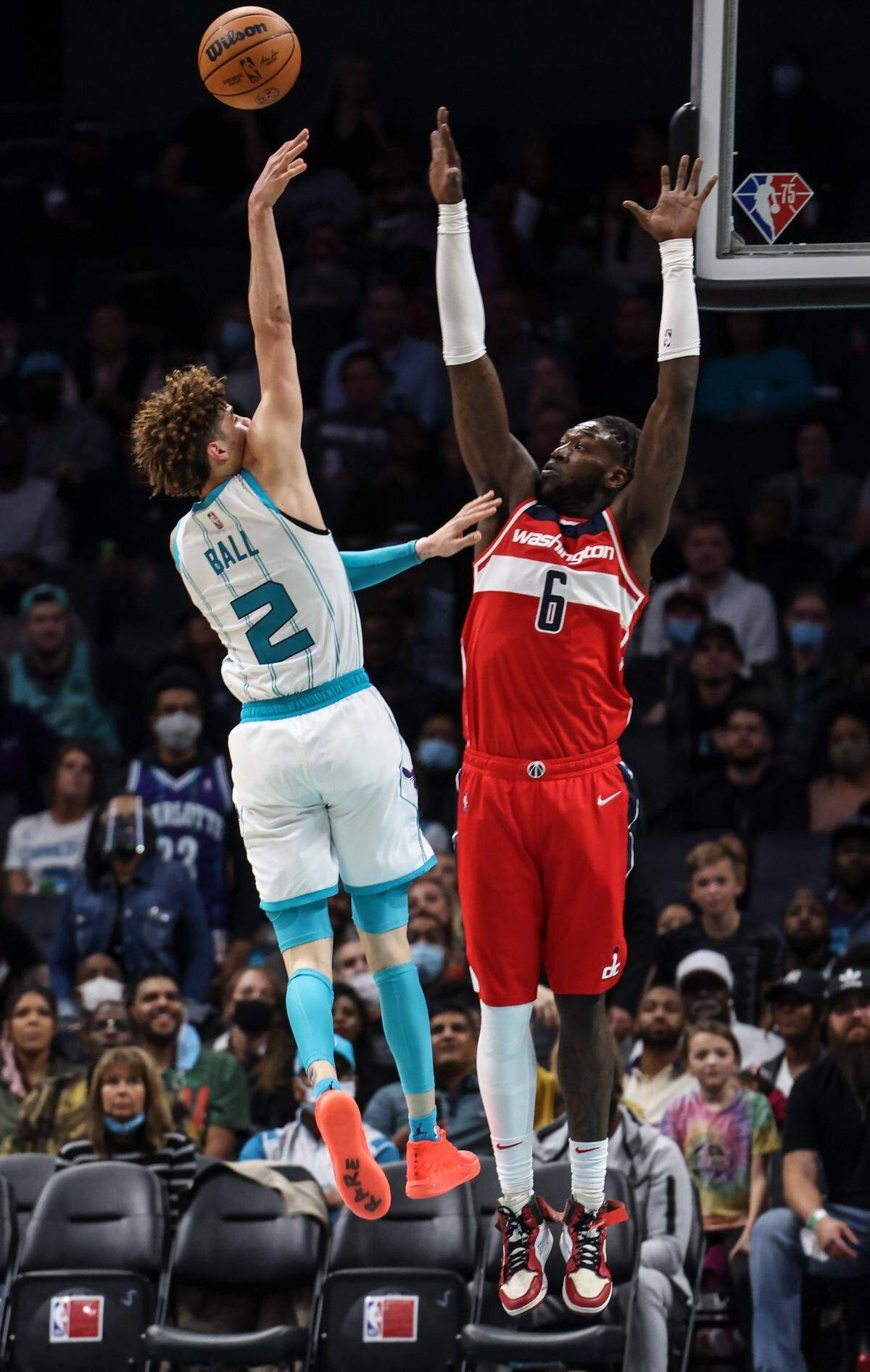 Charlotte Hornets guard LaMelo Ball, left, shoots past Washington Wizards Montrezl Harrell at Spectrum Center in Charlotte on Nov. 17, 2021.