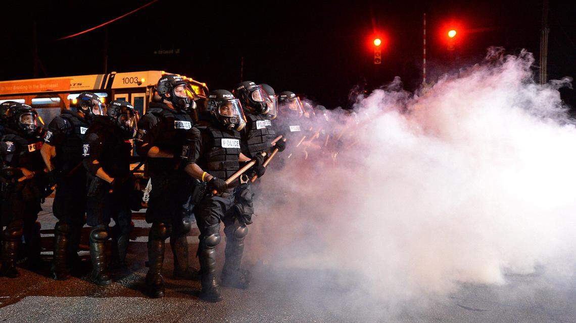 Charlotte-Mecklenburg police officers in riot gear stand in a haze of tear gas on Sept. 20, 2016, watching protestors on Old Concord Road, not far from where police shot Keith Lamont Scott. Rioting and assault charges stemming from that night have been dropped against Charlotte activist Gloria “Glo” Merriweather.