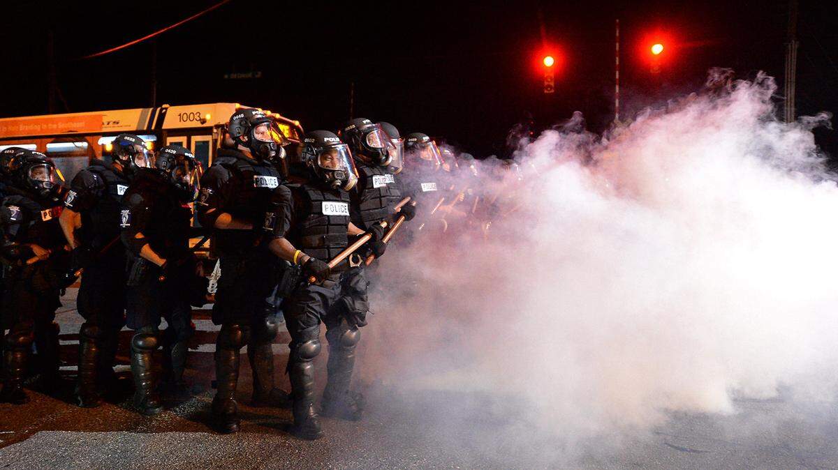 Charlotte-Mecklenburg police officers in riot gear stand in a haze of tear gas on Sept. 20, 2016 not far from where police shot Keith Lamont Scott.
