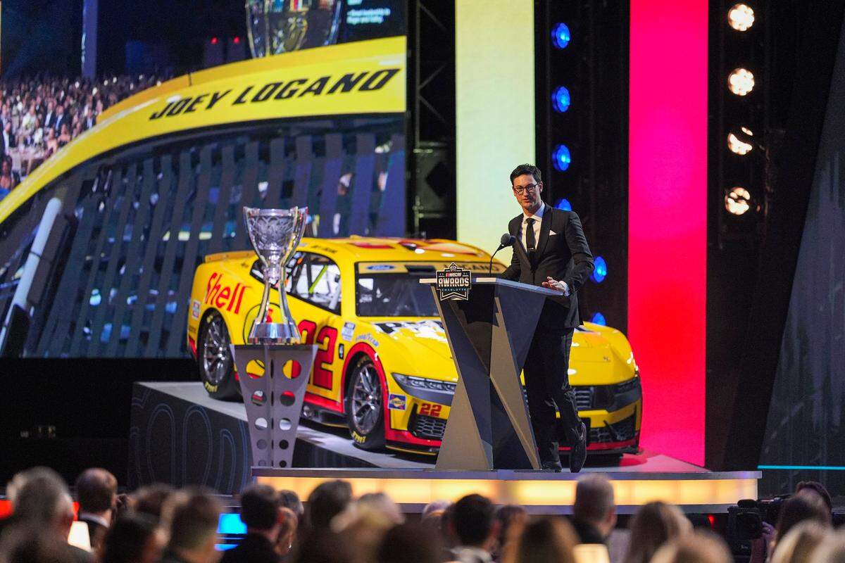Nov 22, 2024; Charlotte, NC, USA; NASCAR Cup Series driver Joey Logano (22) talks to the audience after being announced as the three time Cup champion during the NASCAR Awards Banquet at Charlotte Convention Center.