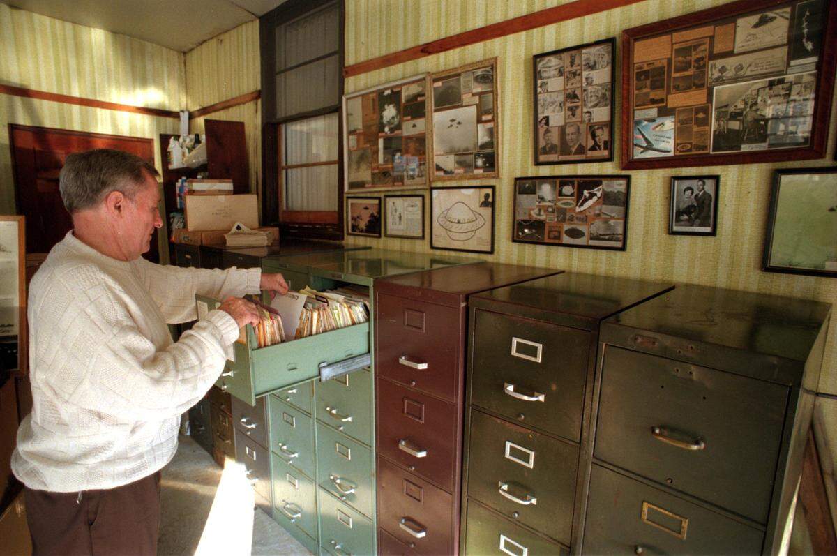 Photo from 1998: George Fawcett looks through his extensive files in the garage of his Lincolnton home. Shipping his UFO collection off to the museum in New Mexico will leave Fawcett with a cleaner garage, attic and living room.