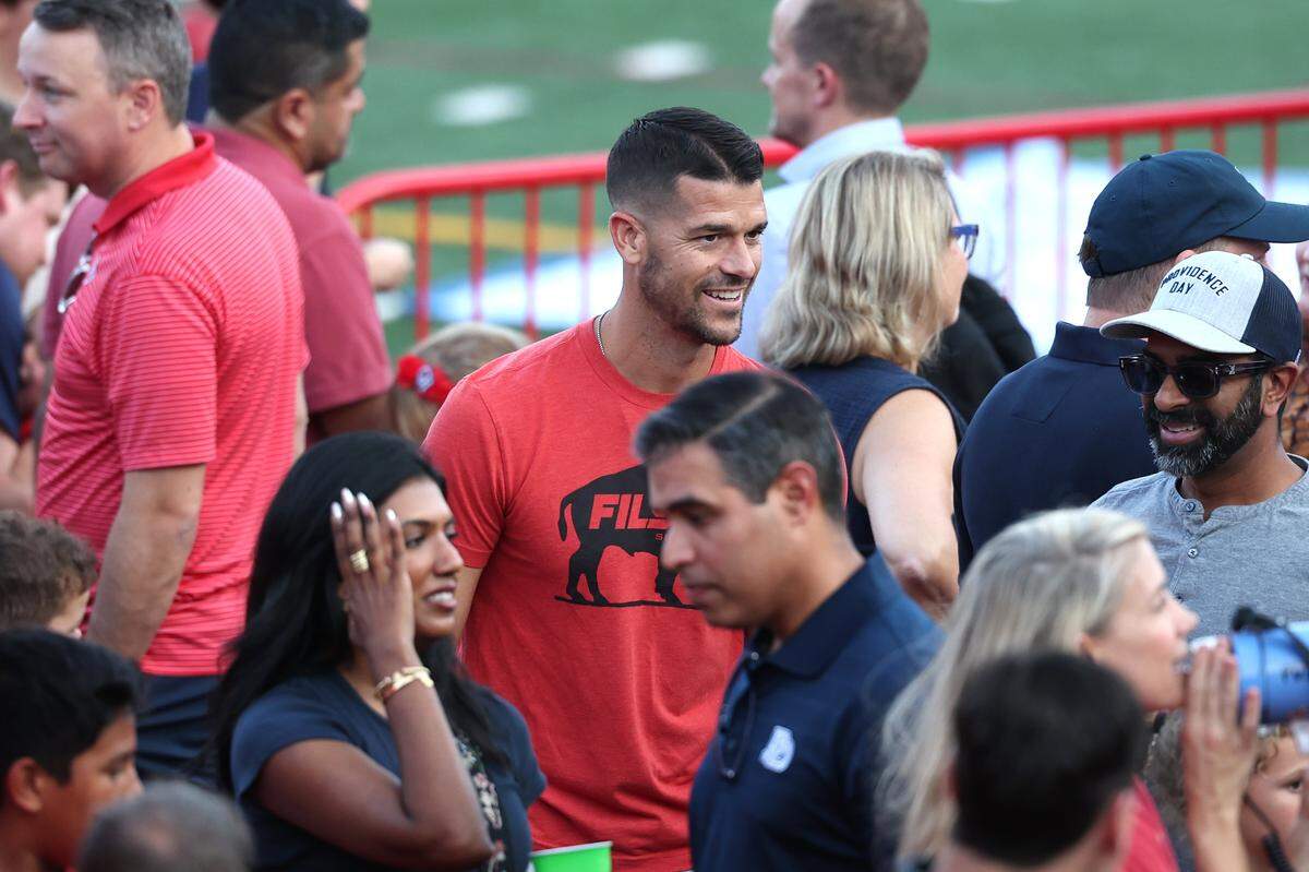 Carolina Panthers head coach Dave Canales, center, joins other Providence Day School families for food prior to the Chargers game against Rabun Gap on Friday, September 19, 2025. Providence Day defeated Rabun Gap 55-34.