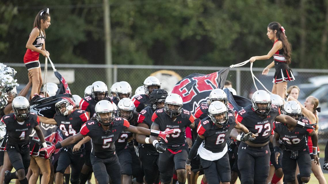 The Butler Bulldogs led by Keyon Lesane (5) and Jaden Clark (6) take the field to face Myers Park at a prep football game at Butler High School Friday, October 5, 2018 in Matthews, NC. Photo by JASON E. MICZEK - Special to the Observer