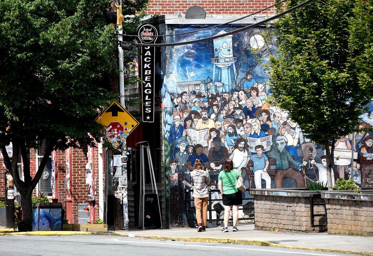 Passersby stop to take a photo of a mural along north Davidson.