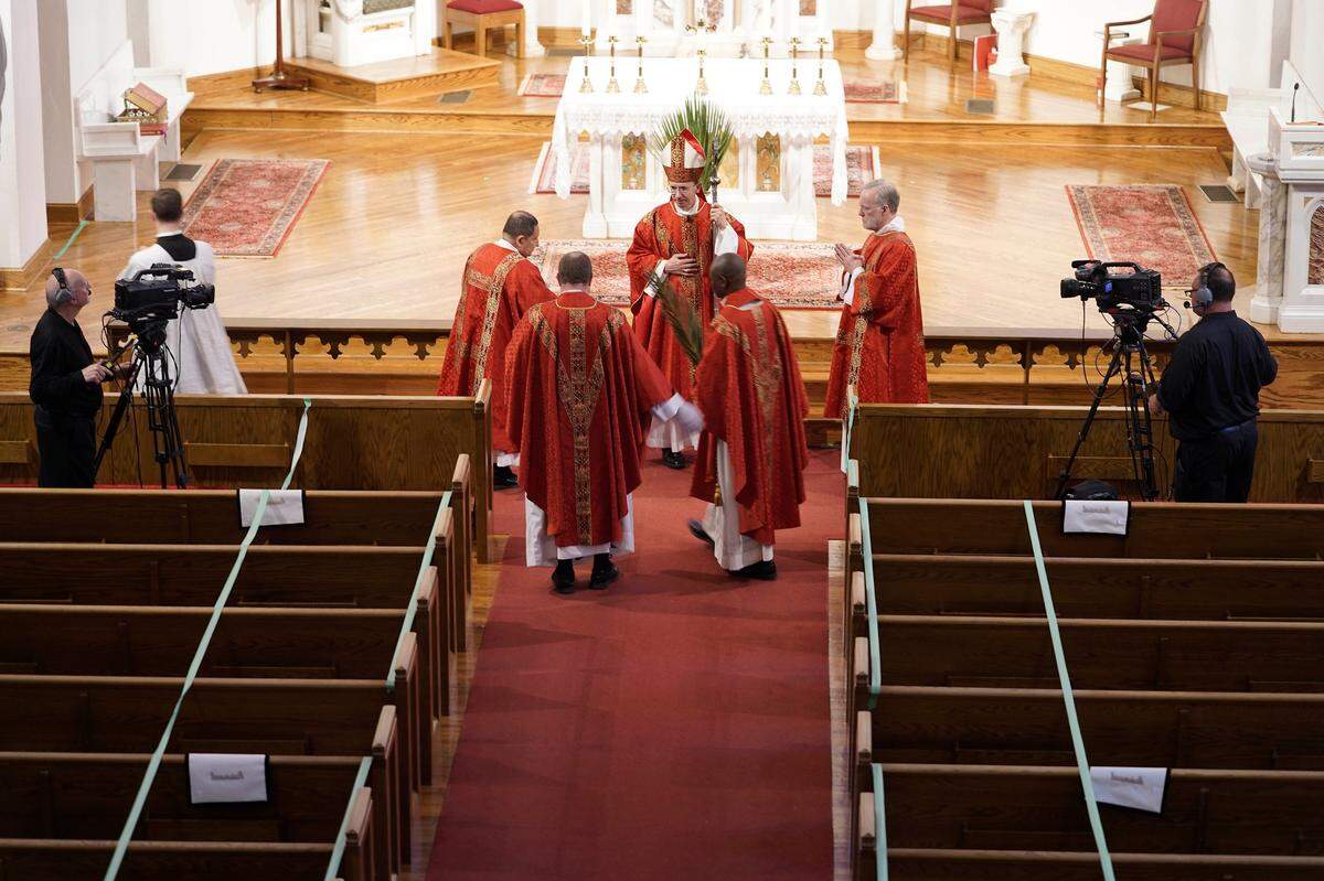 The Most Rev. Peter Jugis, center, Bishop of Charlotte, closes out Palm Sunday services inside the empty St. Patrick Cathedral in Charlotte on Sunday, April 5, 2020. Due to the coronavirus pandemic, the service was closed to the public but was live streamed across western North Carolina.