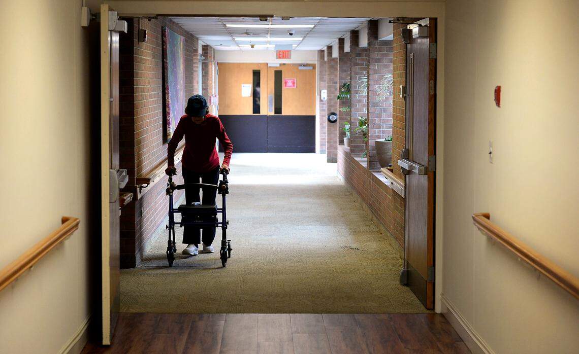 A resident of a nursing home in Salisbury makes her way down a hallway.