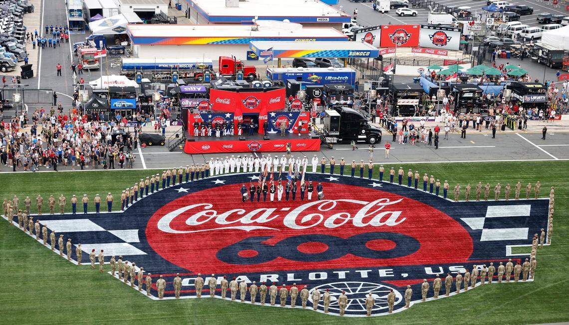 U.S. service members gather around the Coca-Cola 600 logo at Charlotte Motor Speedway during pre-race activities in Concord, NC on Sunday, May 26, 2024.