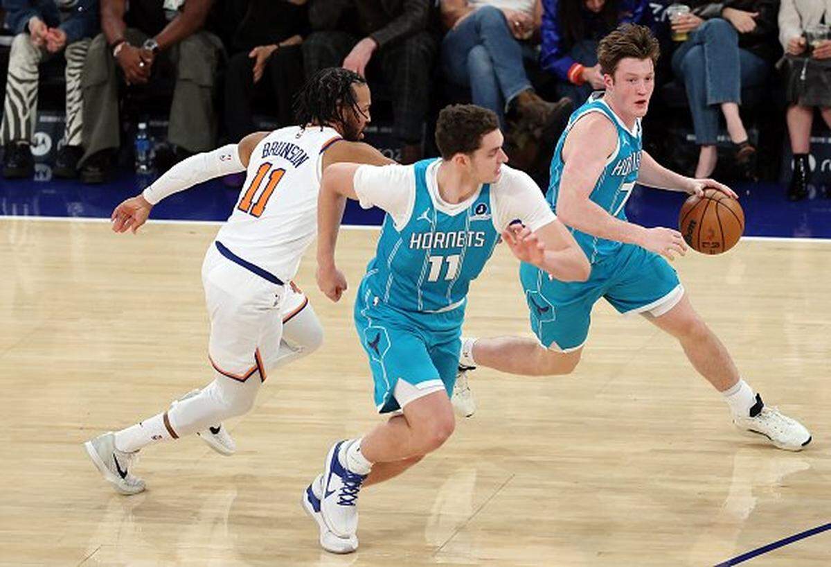 Kon Knueppel #7 dribbles with Ryan Kalkbrenner #11 of the Charlotte Hornets as Jalen Brunson #11 of the New York Knicks defends during the first half at Madison Square Garden on October 17, 2025 in New York City.