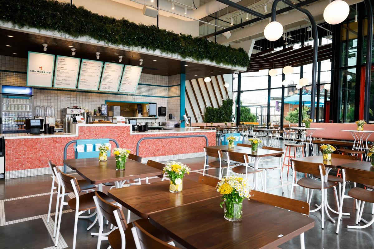 Summerbird’s dining room plays off the summer theme with greenery for a backyard atmosphere.