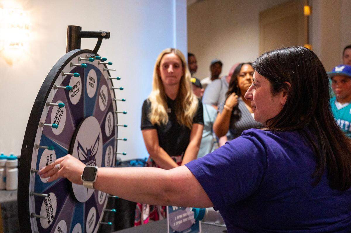 Danielle Pollizzi spins a wheel to receive Charlotte Hornets merchandise during the Hornets 2025 Draft Party in Charlotte, NC, Wednesday, June 25, 2025.