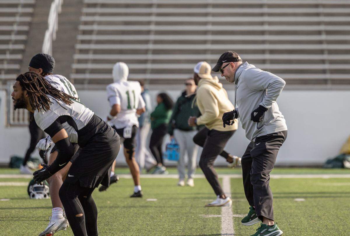 Charlotte 49ers coach Tim Albin warms up with players during spring football practice at Jerry Richardson Stadium in Charlotte, North Carolina, on Tuesday, March 24, 2026.