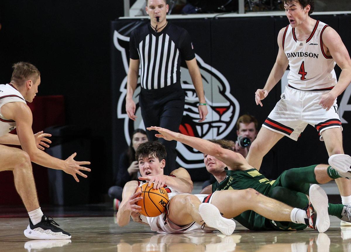 Davidson’s Sean Logan, center, looks for help after grabbing a loose ball during the game at Belk Arena in Davidson, NC on Tuesday, December 10, 2024.
