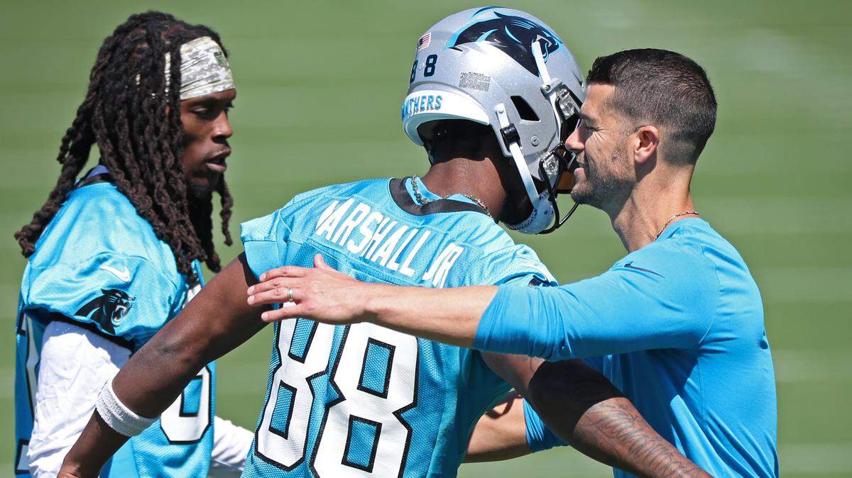 Carolina Panthers wide receiver Terrace Marshall, center, hugs head coach Dave Canales, right, during the team’s voluntary minicamp practice on Tuesday, April 23, 2024.