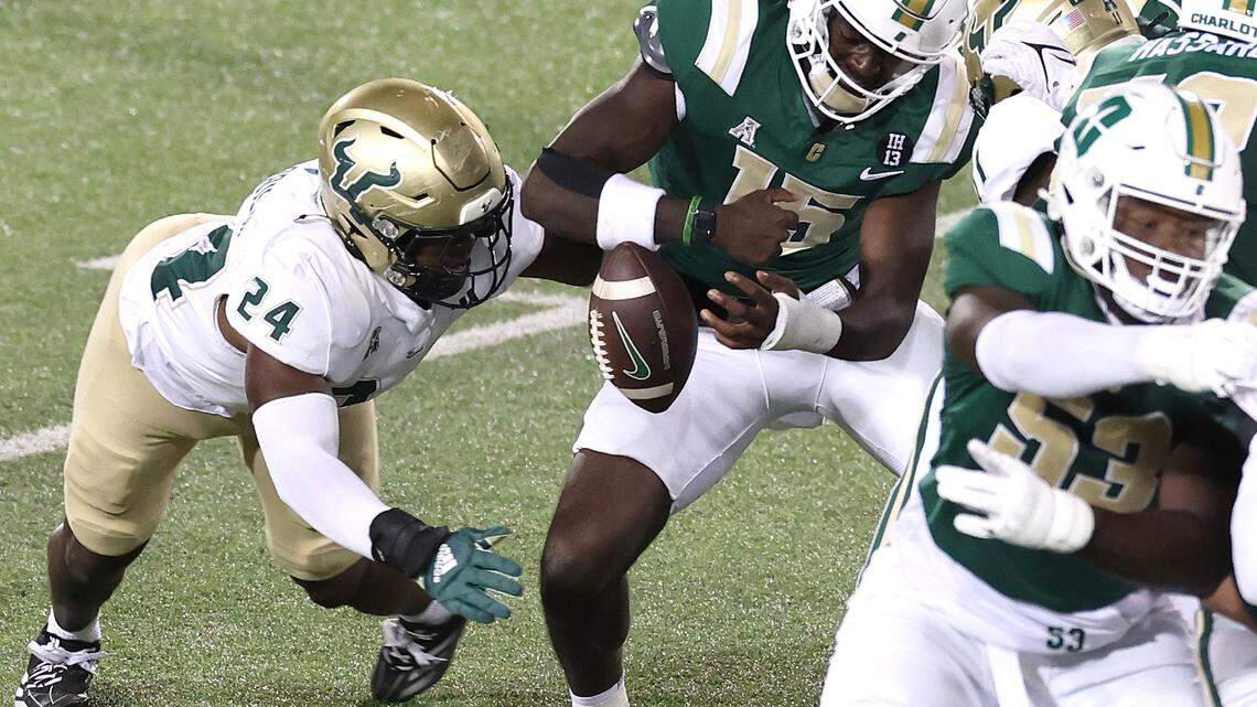 Charlotte 49ers quarterback Deshawn Purdie, center, fumbles the ball as South Florida linebacker Mac Harris, left, rushes around the left side during action on Saturday, November 16, 2024 at Jerry Richardson Stadium.