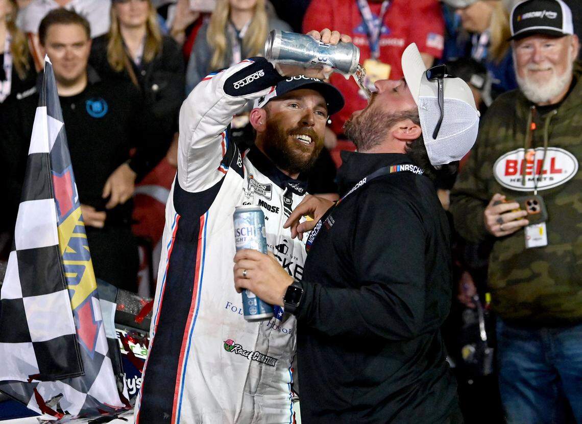 NASCAR Cup Series driver Ross Chastain, left, shares a drink with a friend in Victory Lane as he and his team celebrate winning the Coca-Cola 600 at Charlotte Motor Speedway in Concord, NC on Sunday, May 25, 2025.