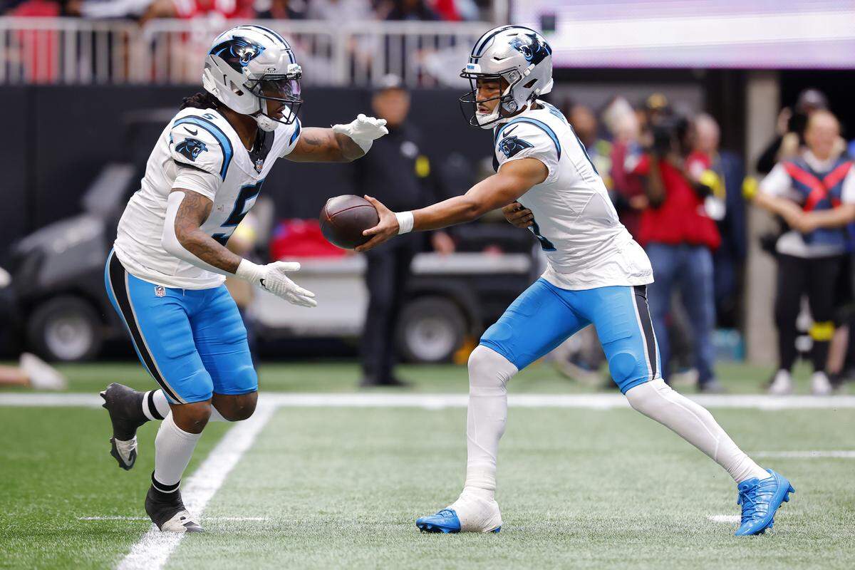 Carolina Panthers QB Bryce Young hands the ball off to Rico Dowdle (5) during Sunday’s second quarter at Mercedes-Benz Stadium in Atlanta. 