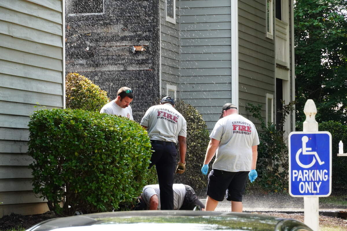 Charlotte firefighters attempting to figure out how to turn off the spouting water from a broken pipe on Thursday morning.