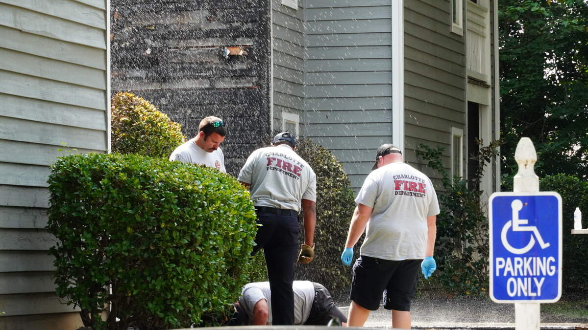 Charlotte firefighters attempting to figure out how to turn off the spouting water from a broken pipe on Thursday morning.