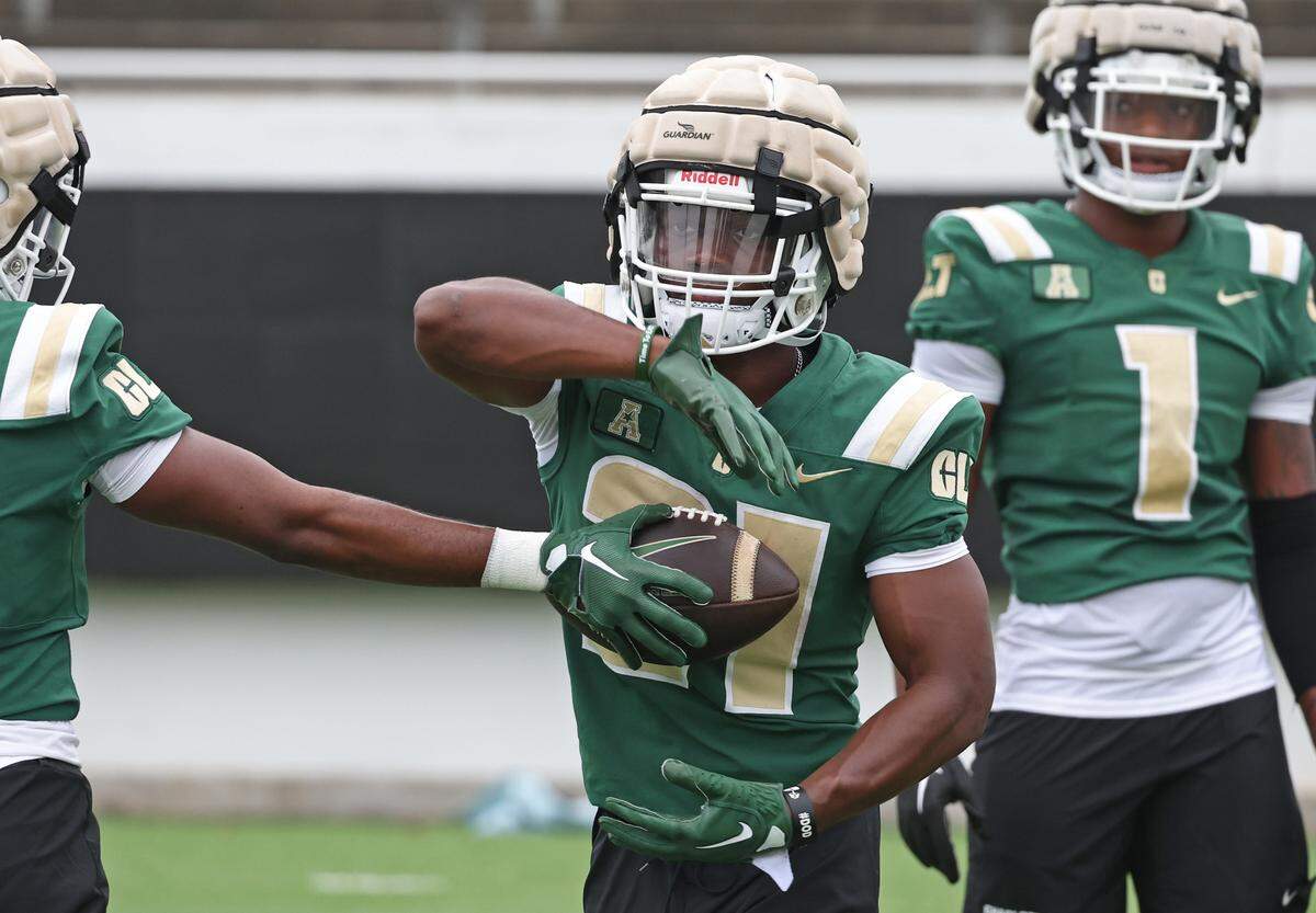 Charlotte 49ers running back Henry Rutledge prepares to secure the ball during a handoff drill at the team’s first practice on Friday, August 4, 2023.