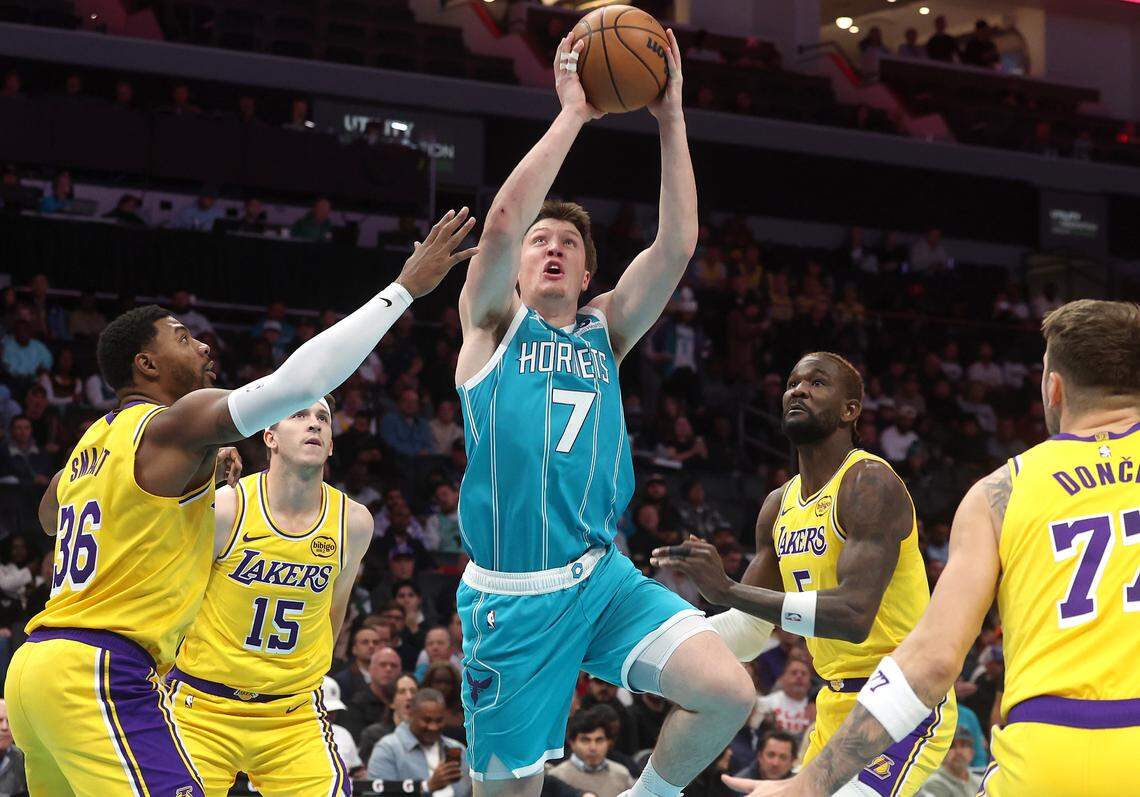 Charlotte Hornets guard/forward Kon Knueppel, center, drives into the lane for a shot as the Los Angeles Lakers defense converges during action on Monday at Spectrum Center.