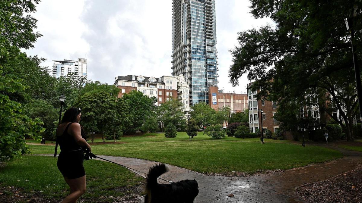A woman walks her dog on Tuesday, May 13, 2025 at Fourth Ward Neighborhood Park in Charlotte, NC. 
