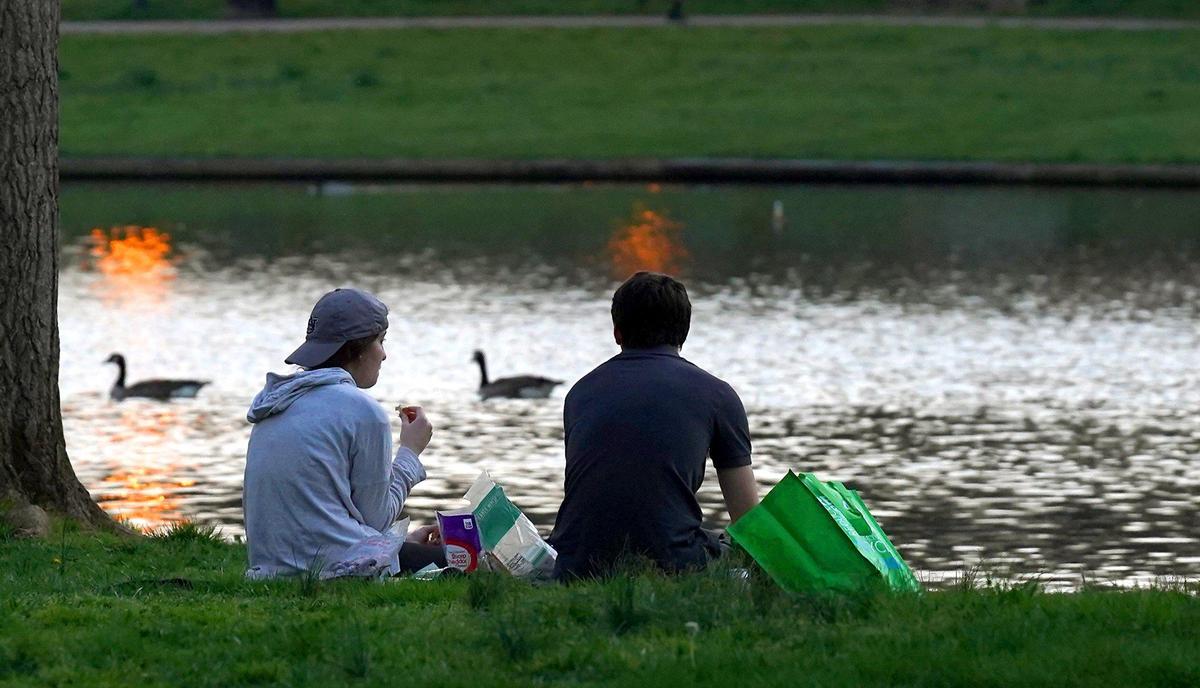 People relax along the lake at Freedom Park in Charlotte, NC on Thursday, March 19, 2020.