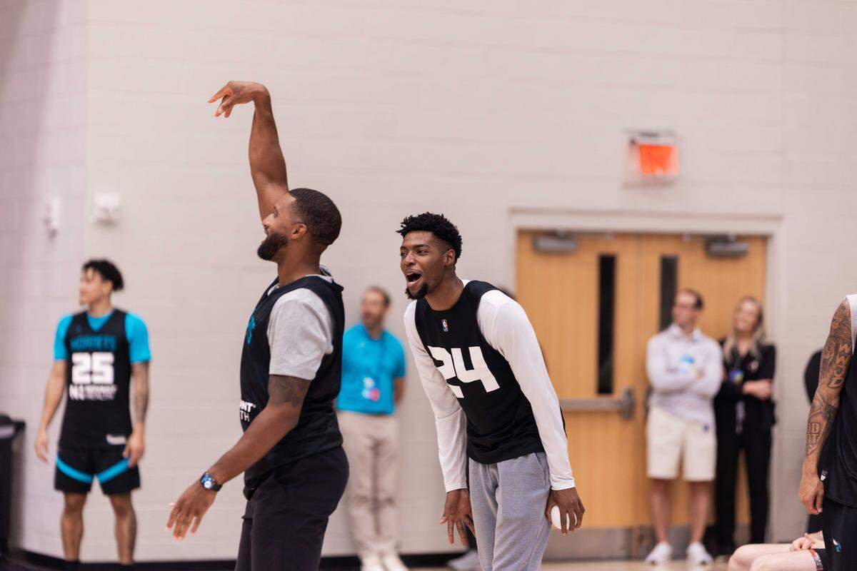 Charlotte Hornets coach Charles Lee puts up a shot as Brandon Miller jokes around with him during team’s purple & teal scrimmage at Queens University on Tuesday, October 7, 2025.