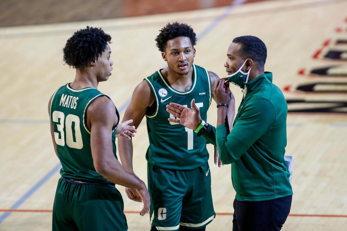 Charlotte 49ers head coach Ron Sanchez talks to Charlotte guards Jhery Matos (30) and Jahmir Young (1) as they play Davidson in the second half of a college basketball game in Davidson, N.C., Tuesday, Dec. 15, 2020.