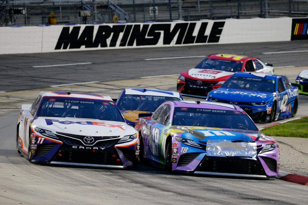 Denny Hamlin (11) and Kyle Busch (18) come through a turn during a NASCAR Cup Series auto race Wednesday, June 10, 2020, in Martinsville, Va. (AP Photo/Steve Helber)