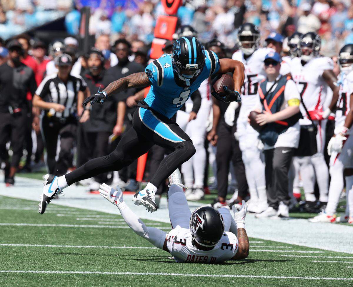 Carolina Panthers' Tetairoa McMillion jumps over Atlanta Falcons' Jesse Bates III during the game at Bank of America Stadium in Charlotte on Sunday, Sept. 21, 2025