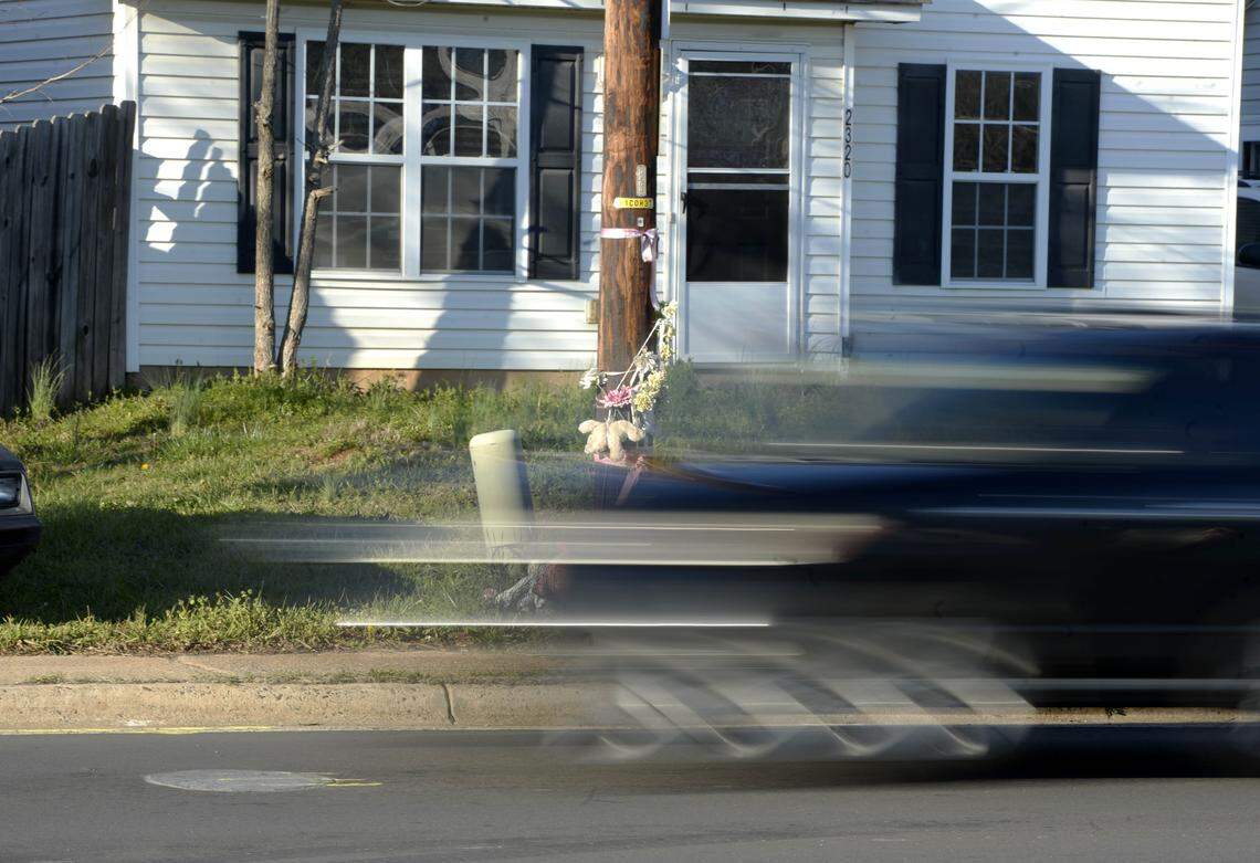 A car passes the memorial for Ty'Asia Young, attached to a utility pole, on March 7, 2018. Ty'Asia Young, 11, was killed while trying to cross West Boulevard after a trip to a convenience store. The boulevard has four lanes, and there is no "island" separating traffic to give pedestrians safety.