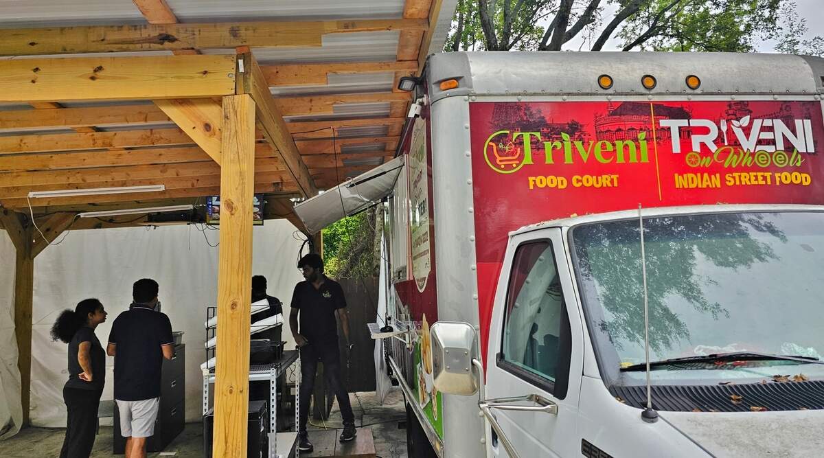 The Triveni Food Truck is parked outside the supermarket, ready to serve.