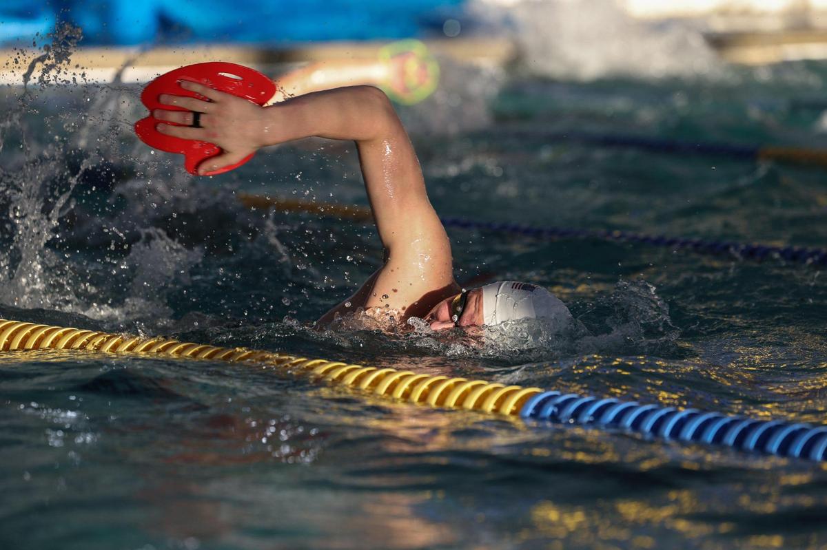 Norvin Clontz, a nationally-ranked swimmer at Charlotte Latin, uses paddles during a drill at a practice for his club team at Blakeney Raquet and Swim Club in Charlotte, NC, on Monday, January 29, 2024.