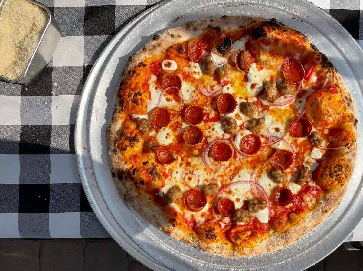 This pie from Bird Pizzeria features mozzarella, pepperoni, sausage and red onions.