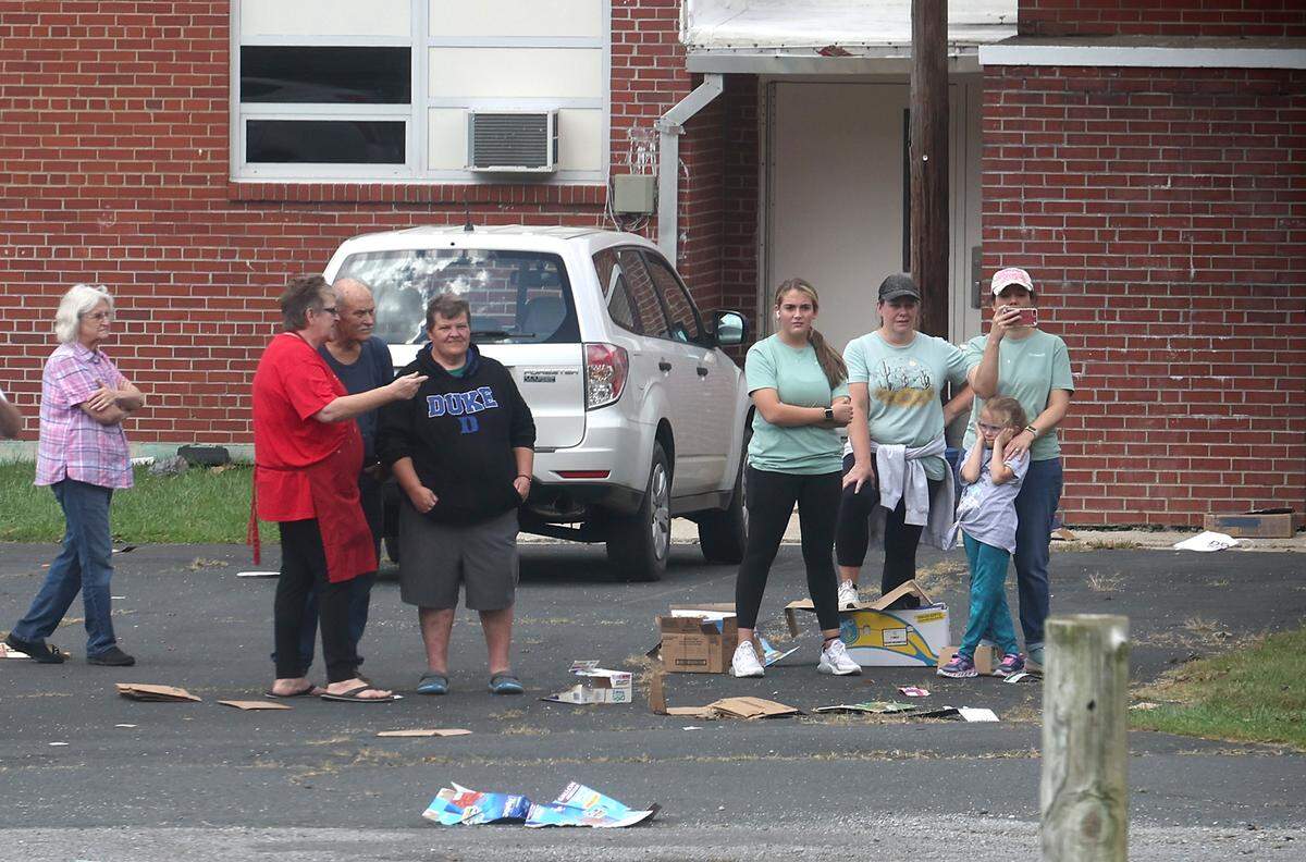 Citizens of the Buladean, NC community stand near the landing zone for Chinook helicopter flown by Bravo Company 1-171 on Thursday, October 3, 2024. The company delivered pallets of bottled water and ready to eat meals to the community in Western North Carolina suffering the effects of Hurricane Helene.