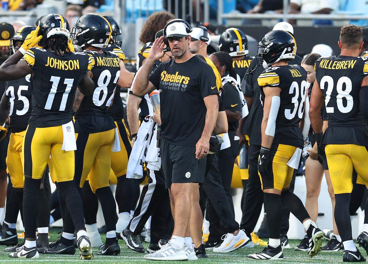Pittsburgh Steelers quarterback Aaron Rodgers, center, stands along the team's sideline during action against the Carolina Panthers at Bank of America Stadium in Charlotte, NC on Thursday, August 21, 2025.