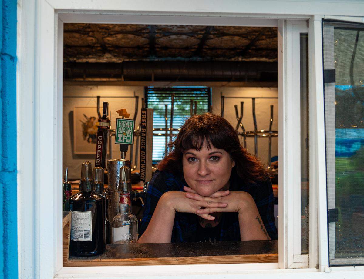 At Dish, front of the house manager Mary Kate Carroll peeks through a new window along the bar that opens to the patio for access to serve drinks.