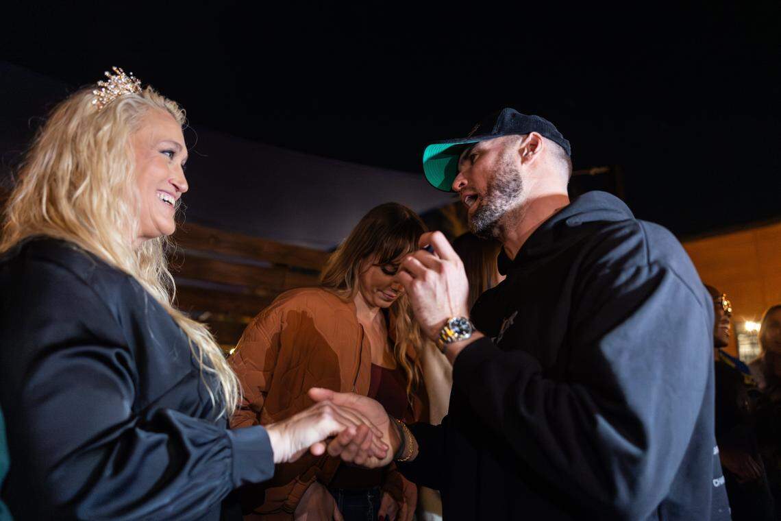 The 6-foot-9-inch, Tall Tour host, Tyler Bergantino, right, crowns the tallest woman, Michelle Hairston, standing at 6-foot-7-inches, during the Tall Tour event at Brewers At 4001 Yancey in Charlotte, N.C., on Saturday, December 6, 2025.
