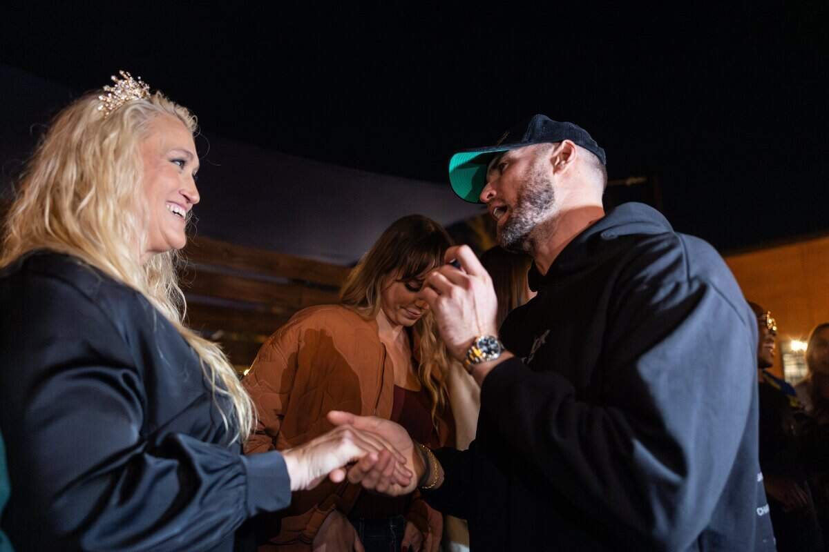 The 6-foot-9-inch, Tall Tour host, Tyler Bergantino, right, crowns the tallest woman, Michelle Hairston, standing at 6-foot-7-inches, during the Tall Tour event at Brewers At 4001 Yancey in Charlotte, N.C., on Saturday, December 6, 2025.